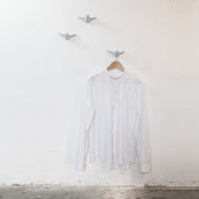 Laden Sie das Bild in den Galerie-Viewer, hellgraue vögel als wandhaken vor einem weißen hintergrund mit einem weißen hemd