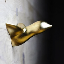 Laden Sie das Bild in den Galerie-Viewer, Ein goldener Vogel in der Dämmerung einer Wand, angebracht mit einem Nagel, konzipiert von Thomas Poganitsch in Wien